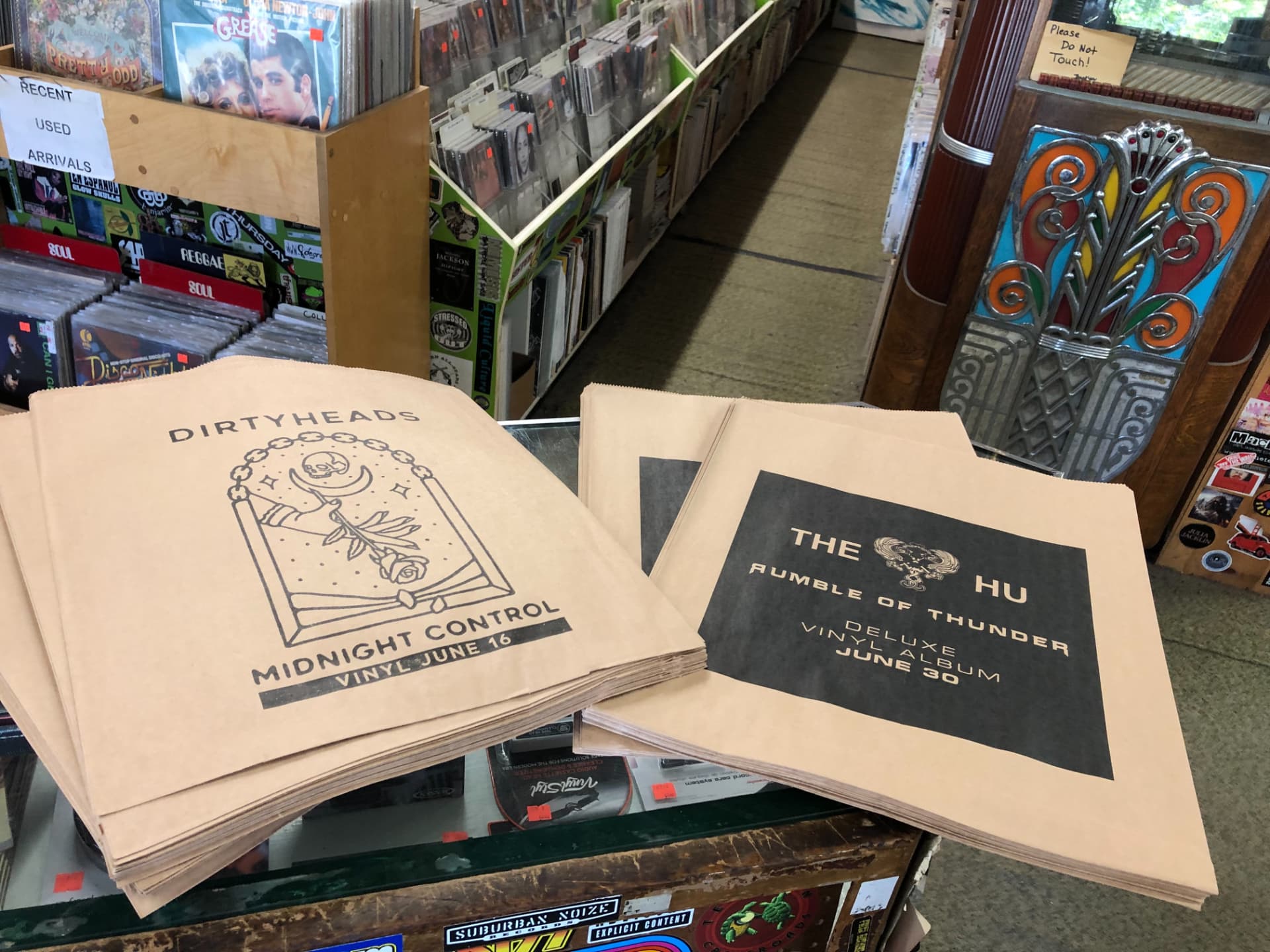 Stacks of printed kraft record store bags on a counter