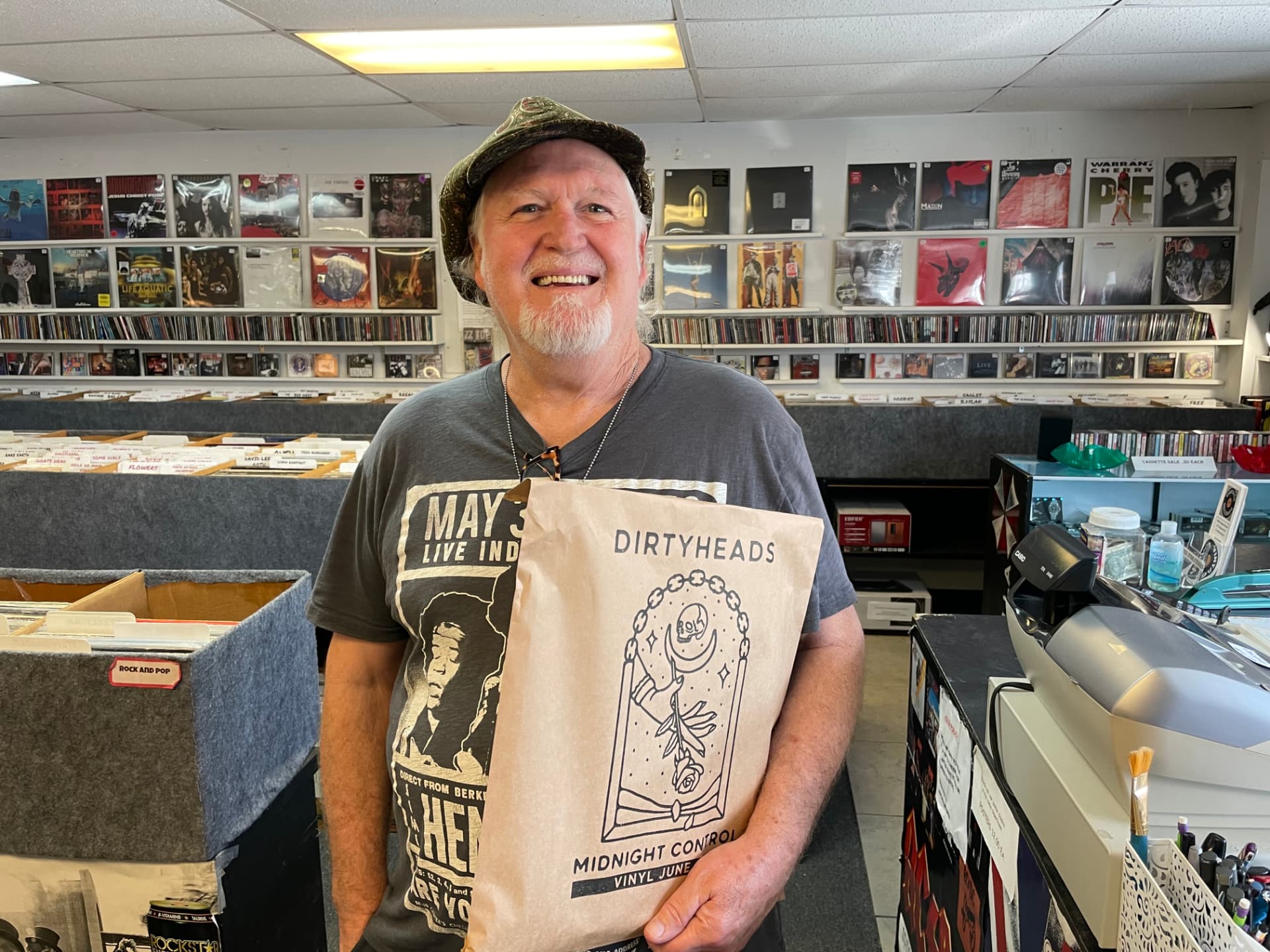 Record store customer holding a kraft bag printed with Dirtyheads album art