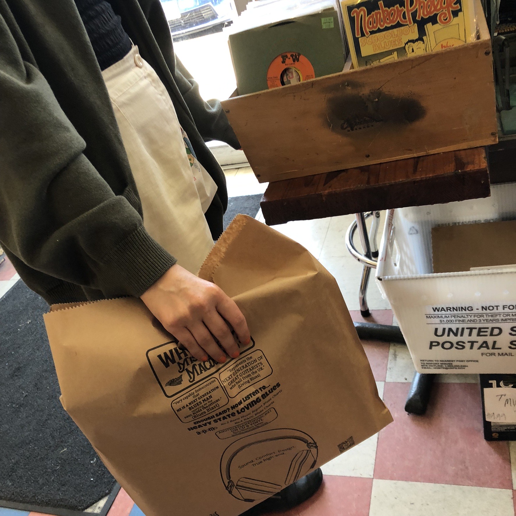 Customer carrying a printed kraft record store bag